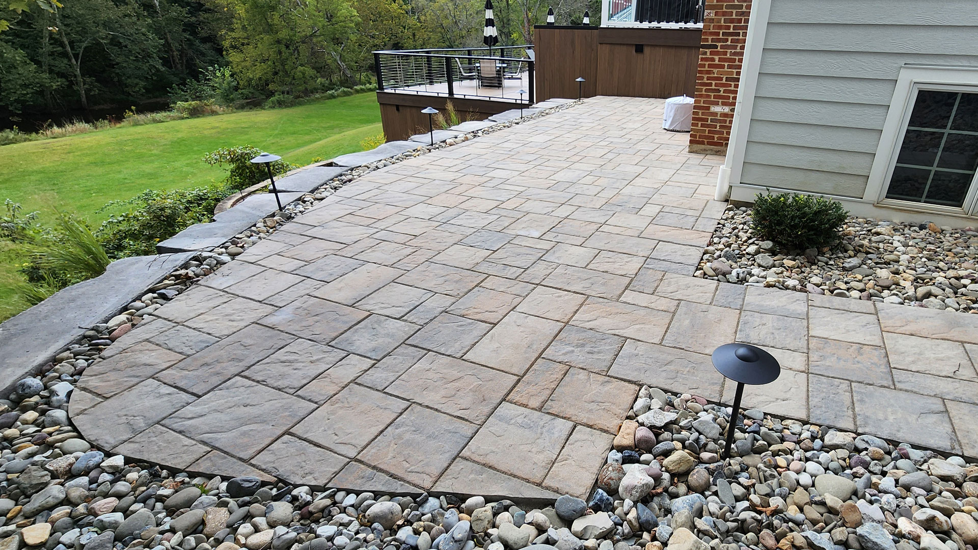 Square Stone Patio bordered with stone and pathway lights